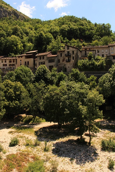Vue d'un village du vercors, avec une rivière en bas au lit très large et des maisons en hauteur