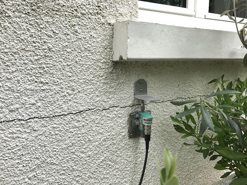 Vue d'un détecteur de fissures sur le mur d'une maison