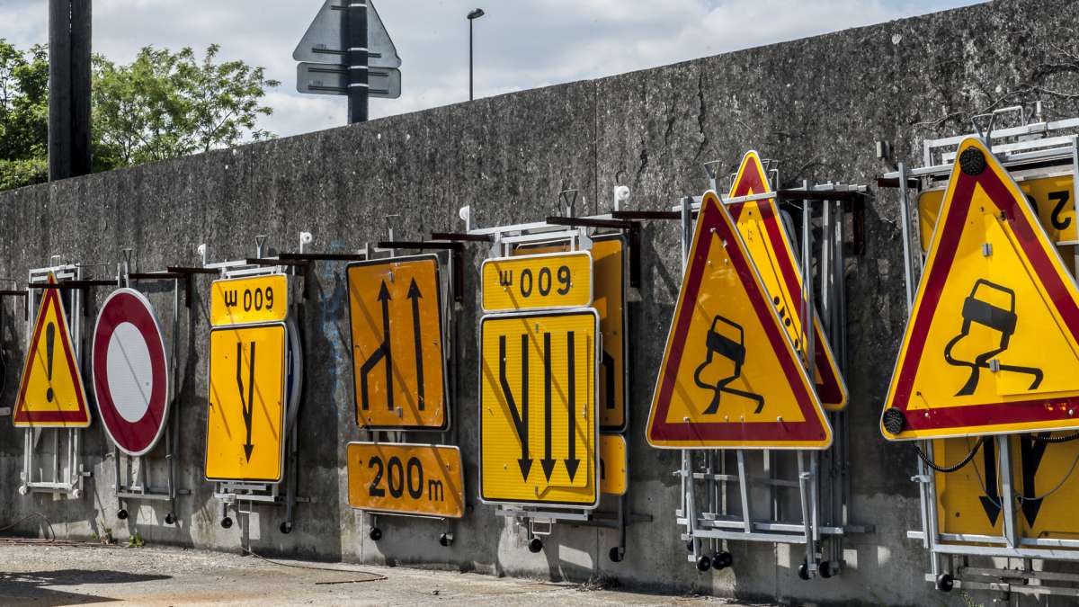 panneaux de signalisation routière alignés contre un mur